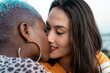 © ADDICTIVE STOCK - Multiracial lesbian couple sitting close together outdoors