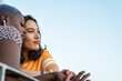 © ADDICTIVE STOCK - Multiracial lesbian couple sitting close together outdoors