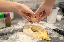  Woman Is Fighting In The Kitchen Breaking Eggs Into Flour And Kneading Dough Into Dumplings.