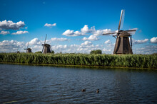 Row Of Windmills By The Water In The Netherlands