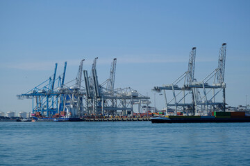  ROTTERDAM, THE NETHERLANDS - New container terminal with a very large container ship and in the foreground a smaller inland container ship on the Maasvlakte of the port of Rotterdam