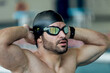 © ADDICTIVE STOCK - Muscular swimmer in goggles and cap against pool