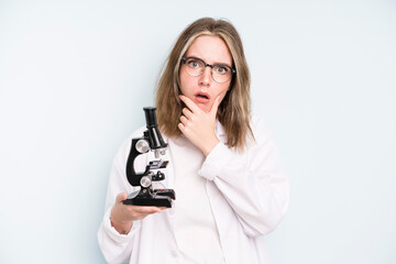 Wall Mural - caucasian pretty woman covering mouth with hands with a shocked. science student with a microscope