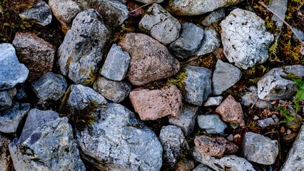 Closeup shot of many dirty rocks in different sizes on the ground