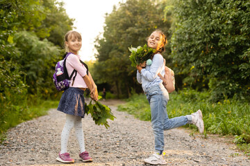 Wall Mural - Two cute smiling 8 years old girls posing together in a park on a sunny autumn day. Friendship concept.