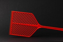 Close-up Shot Of Red Fly Swatter Isolated On Black Background