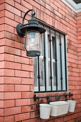 Sticker - Vertical shot of a lamp and a window on a stone wall