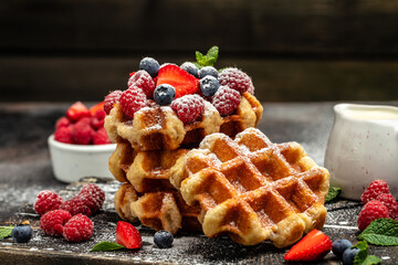 Belgian Waffles sweet desert with raspberries, strawberries and blueberries, sugar powder