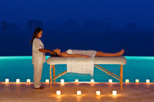 A Woman Receives A Candlelit Poolside Massage At Dusk At A  Three-bedroom Private Pool Villa. Yao Noi. Thailand.