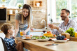 © Goran - Happy mother talking to her small son while giving him orange juice during lunch time at dining table