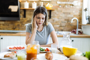 Depressed young woman doesn't want to eat her breakfast