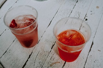 Sticker - Cold red juice in two cups on wooden surface