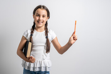 Wall Mural - Lovely little girl standing and holding book over white background