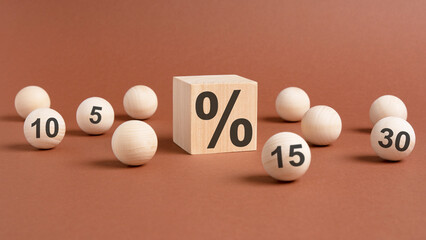 Wall Mural - percent sign on wooden cubes against broun background with wooden balls. concept of sale and discount