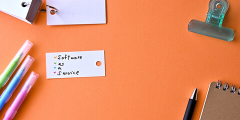 Poster - There is word card with the word Software as a Service on the desk.