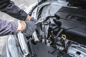 car mechanical engineering hands repairing a car engine automotive workshop with a wrench at worksho