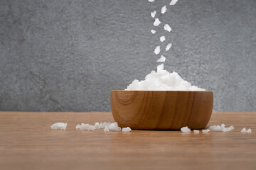 Wall Mural - Sea salt in bowl on wooden texture background