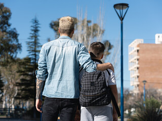 Wall Mural - Father and son walking backwards to school in the morning