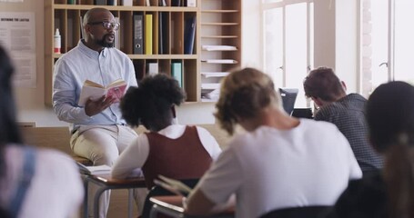 Poster - Classroom teacher reading, teaching and talking to teenager students in high school classroom. Man with story books in studying discussion for learning, education and knowledge to group of young kids