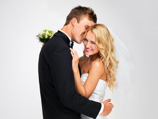 Wedding, couple and marriage with a bride and groom as a couple in studio against a white background. Dress, suit and flowers with a man and woman getting married at a celebration event or ceremony