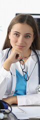 Wall Mural - Portrait of woman doctor with glasses in her hands in clinic office