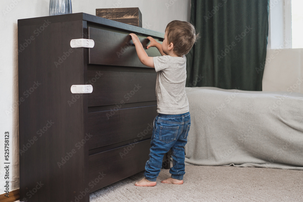 Child unsupervised plays with cabinets. Danger for the baby to pinch ...