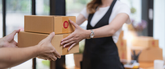 customer receiving a cardboard boxes parcel from delivery man in the morning, delivery service concept.