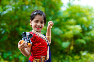 Wall Mural - Cute indian little girl celebrating lord ganesha festival.