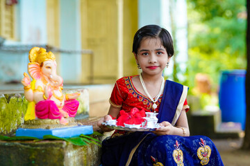 Wall Mural - Cute indian little girl celebrating lord ganesha festival.