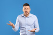Emotional man in casual outfit on blue background