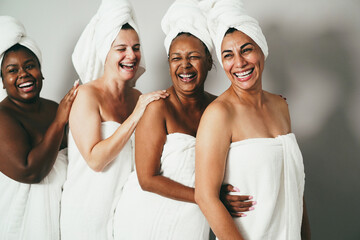 Wall Mural - Multigeneration women with diverse skin and body laughing together while wearing body towels - Focus on right woman face