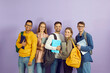 © Studio Romantic - Happy smiley diverse university or college students in studio. Cheerful multiethnic young people in modern casual wear with bags, laptop PCs and class textbooks standing together and looking at camera