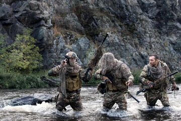 Wall Mural - Mercenary soldiers ford a river during a special operation. COLLAGE - one model in three poses