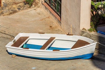 Wall Mural - Small white and blue row boat moored on the quay of the port. Ancient Tellaro village, Lerici municipality, La Spezia province, Liguria, Italy, southern Europe.