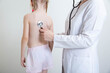 A pediatrician doctor listens with a stethoscope to the lungs of a child who has wheezing in the lungs. Bronchitis and pneumonia with colds and the virus in children, virus