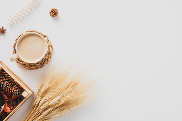 Wall Mural - Cozy home desk table with coffee cup, wheat, box with dry petals, pine cones, on white background. Autumn composition. Flat lay, top view, copy space. Hygge, nordic style.