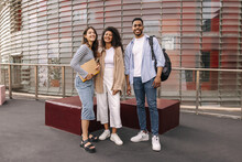 Full Length Young Interracial Team Of Students Posing Looking At Camera Having Break Between Classes. Brunette Guy And Girls Wear Casual Clothes. Happy Day Concept