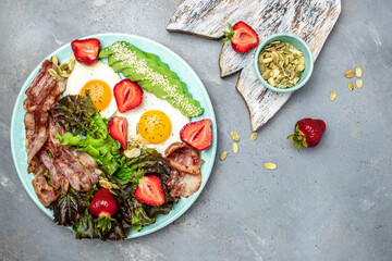 Poster - Fried egg bacon with avocado, strawberries and fresh salad. Delicious breakfast or lunch, Ketogenic, keto or paleo diet, Food recipe background. Close up