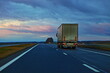 Heavy semi truck on countryside highway road on bright blue dramatic clouds background. Uhfnsportation logistics in Europe
