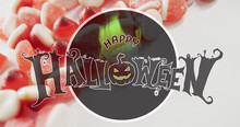 Happy Halloween Text Banner Against Close Up Of Candy Corns On White Surface