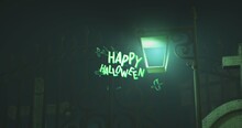 Digital Composite Image Of Illuminated Lamp Post By Closed Gate At Night, Happy Halloween Text