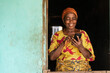 © Confidence - happy elderly african woman using her phone