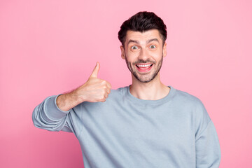 Poster - Portrait of positive cheerful man hand finger demonstrate thumb up isolated on pink color background