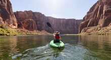 Adventurous Woman On A Kayak Paddling In Colorado River. Glen Canyon, Arizona, United States Of America. American Mountain Nature Landscape Background. Adventure Travel