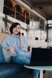 © mariiaplo - Young beautiful woman using smartphone for business, talking in coffee shop cafe