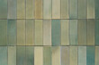 Texture and pattern of a green ceramic wall tiles, grunge square mosaic close up, background, retro facade of the building.