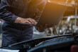 © aksonsat - Male mechanic is checking the car maintenance lists for maintenance and fixing the car.
