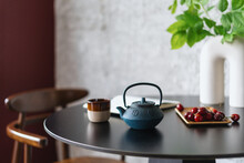 Teapot With Herbal Tea And Ceramic Cup On Wooden Table