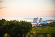 Empty Outdoor Rocking Chairs At Coastal Summer Sunrise