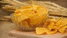 Selicious Nachos Chips In Glass Bowl On A Cutting Board, Isolated On Burlap Background